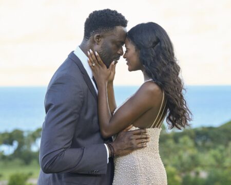 Charity and Dotun rest their foreheads against each other tenderly