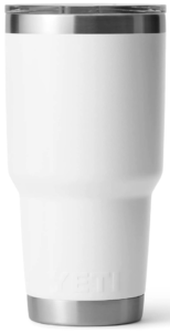 A White enamel yeti tumbler with a narrow bottom to fit in a car cupholder with a silver band at the top and bottom