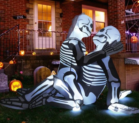 Two inflatable skeletons, one straddling the other with its hands on the lower skeleton's face. It's like they're boning, I swear.