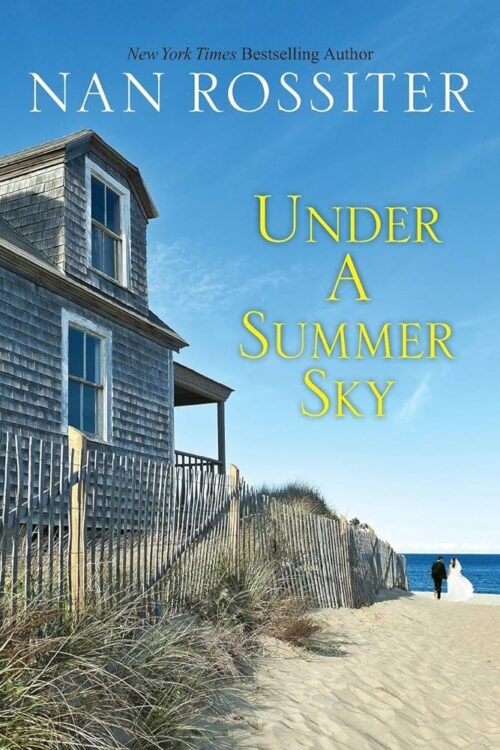 Under a Summer Sky - a blue sky with no clouds, below a grey shingled beach house looking out over the ocean alongside a dune path in the sand, with a tiny bride and groom near the water