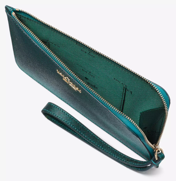 An overhead shot at an angle of the wristlet with the zipper open to show the green fabric lining