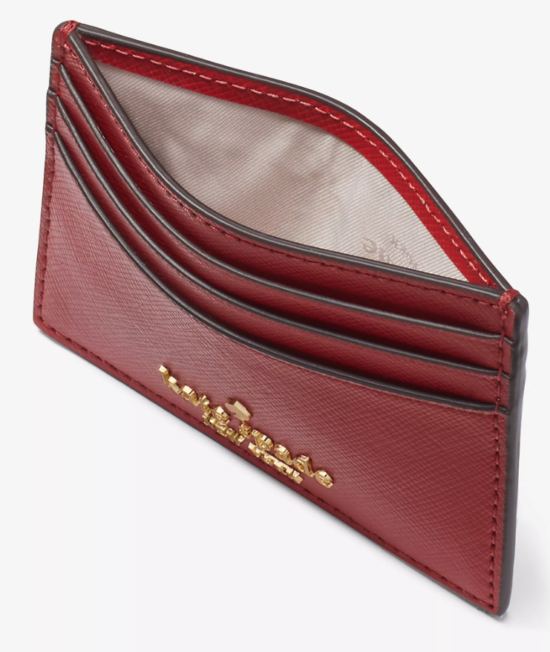 An overhead view showing the red leather card wallet flexed to show the interior fabric compartment