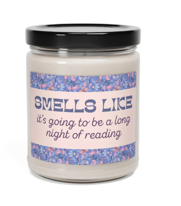 A jar candle with a purple and pink label that reads SMELLS LIKE it's going to be a long night of reading