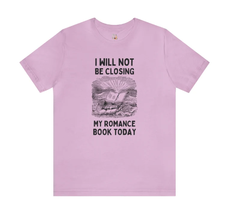 A pink shirt with black illustration of a book open against a field of other books, and the words I WILL NOT BE CLOSING MY ROMANCE BOOK TODAY