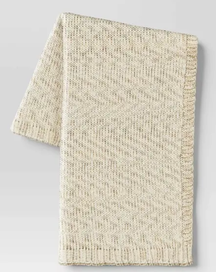 A white woven throw with metallic threads in silver 
