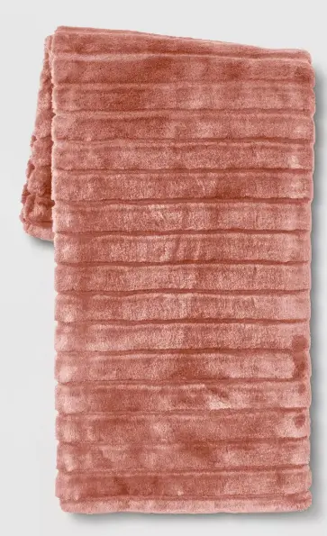 A ribbed faux fur blanket with horizontal stripes in a deep coral pink 