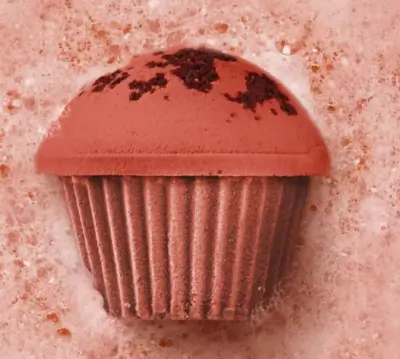 Brown Sugar and Toasted Almond bath bomb shaped like a cupcake in a bubbly bath it's so cute