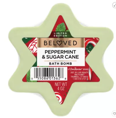 A six pointed green star bath bomb with a red label that reads Peppermint and sugar cane