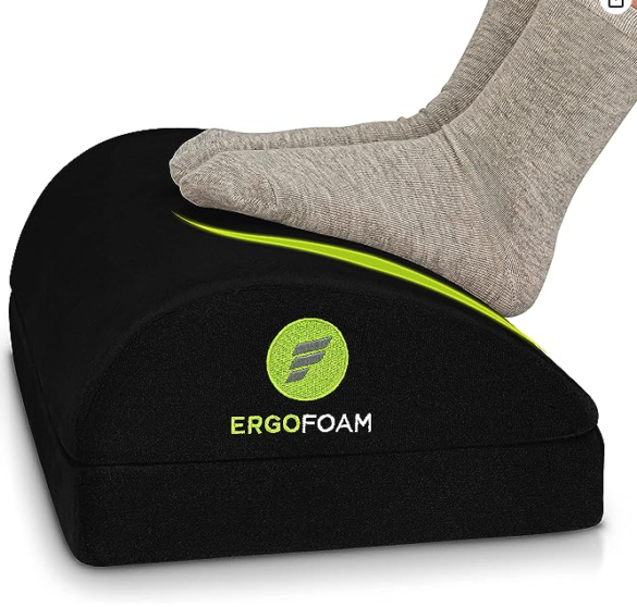 Ergo foam footrest - a pair of sock clad feet resting on a fuzzy domed footrest with ERGOFOAM on the side in green