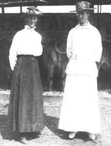 Black and white photo of Louise and Annie, faces blurred, one in a white blouse and dark skirt and the other in all white.