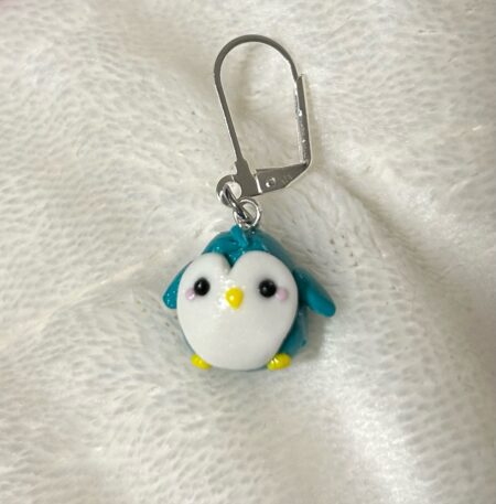 A blue and white penguin stitch marker