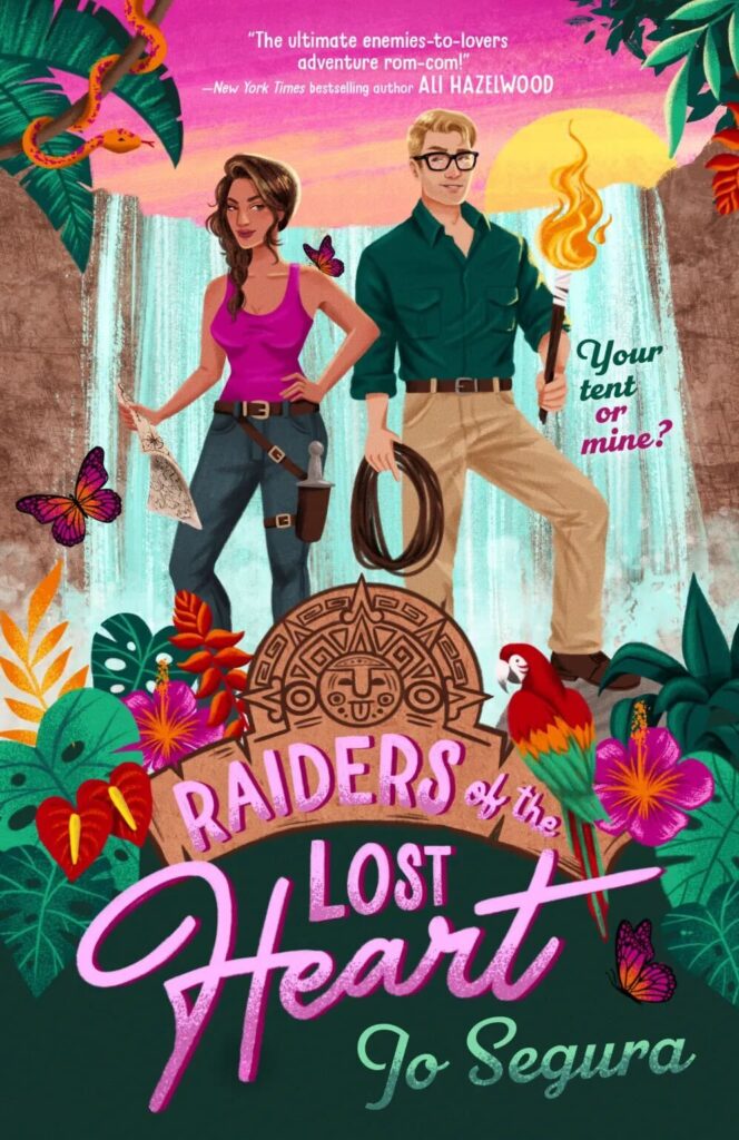 Raiders of the Lost Heart by Jo Segura. An illustrated cover of a man and woman standing on a hill of flowers with a waterfall in the background. The woman has on a pink tank top and jeans. She's holding a map in her hands and a sheathed knife hangs at her hip. The man has on khakis and a green, button down. He's wearing glasses and holding a coiled bunch of rope and a lit torch.