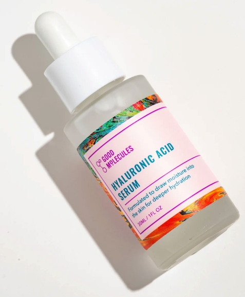 A frosted glass bottle with a dropper lid in white with a pink label that says Hyluronic Acid serum 