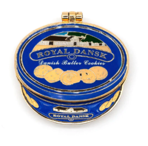 An enamel pin of a Royal Dansk Cookie tin in blue an gold