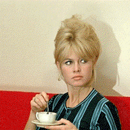 A woman stares and stirs her coffee