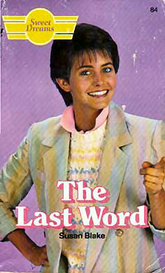 A very young looking Courtney Cox with a pastel, watercolor esque blazer of blues, yellows, and pinks. She also has on a pink and yellow polo with a popped color. Her hair is cut short and she's pointing at something off cover.