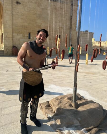 Joey stands in front of the sausage wheel.
