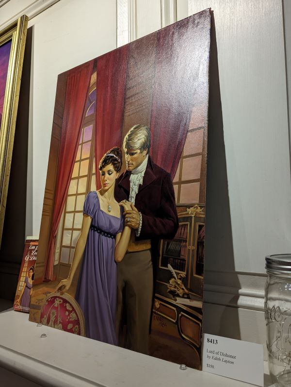 A painting of a woman in a purple empire waist gown being embraced by a blonde dude in a cutaway coat Taken from the side to avoid glare