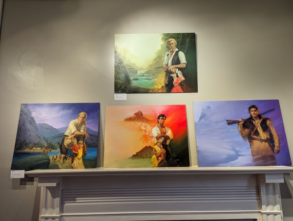 a set of four paintings above a mantel each featuring a dude in historical garb and mostly done in blues and purples with one in the middle that's red and orange