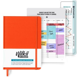 Wilkii ADHD planner - a 90 day planner in a red softcover with a bookmark. Behind it are previews of the schedue page and a tracking graph
