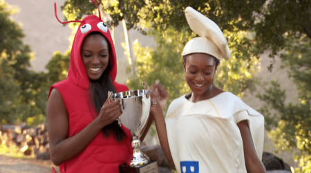 Evalin and Kelsey hold up a trophy while dressed like a lobster and a stick of butter