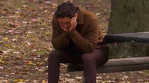 Joey sits on a park bench with his head in his hands