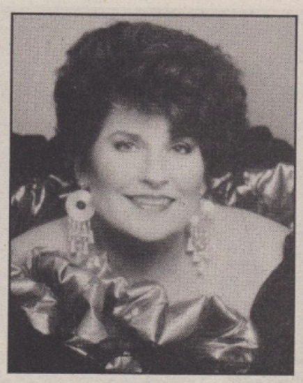 A Glamour Shot author photo with teased hair, big earrings, and shiny ruffled strapless top
