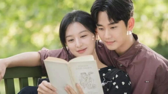 A scene of the two leads on a bench in the park reading a book, She is leaning back against him while he has his arm around her shoulders 