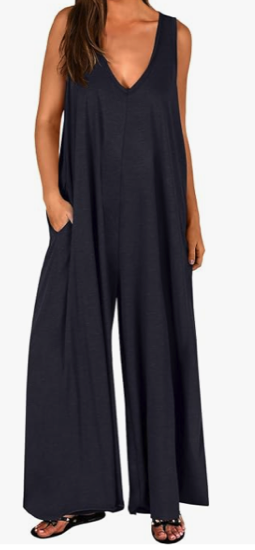 A woman with light skin wears a v neck jumpsuit with no sleeves and wide legs 