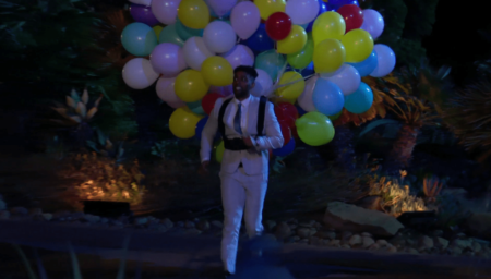 A man has a shitton of balloons strapped to him 