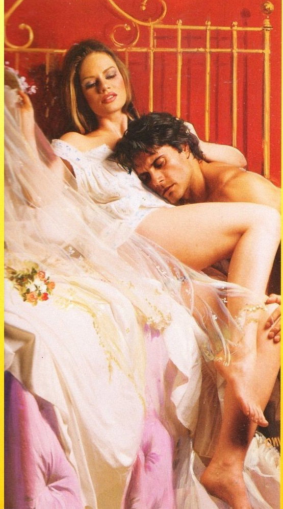 A white woman with straight brown hair reclines on a brass bed with a red wall behind her. She's on her back with one leg bent toward DeSalvo, who looks dazed and confused and has his head on her stomach, the position of his body suggesting he is about to go down town