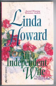 A blurry soft focus image of some red flowers with Linda Howard An Independent Wife over top in blue 