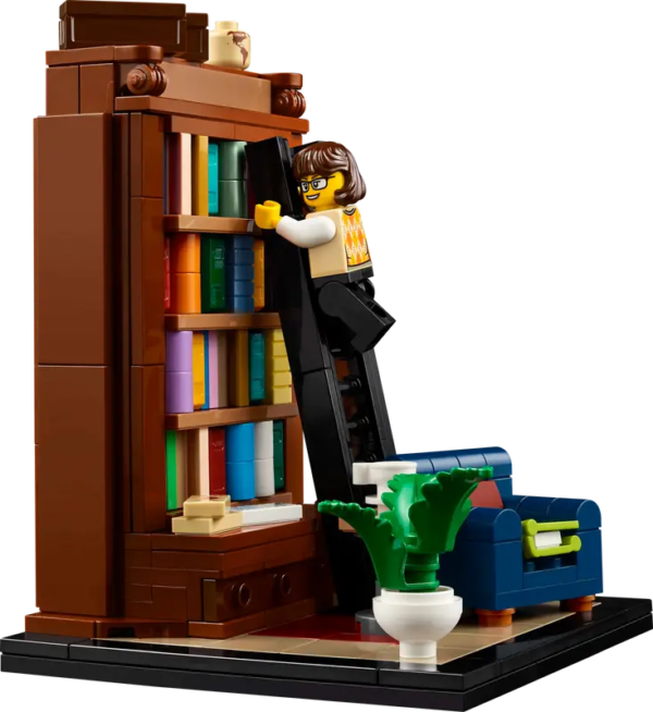 The lego minifig is climbing the library ladder and there's a plant in the corner of the set
