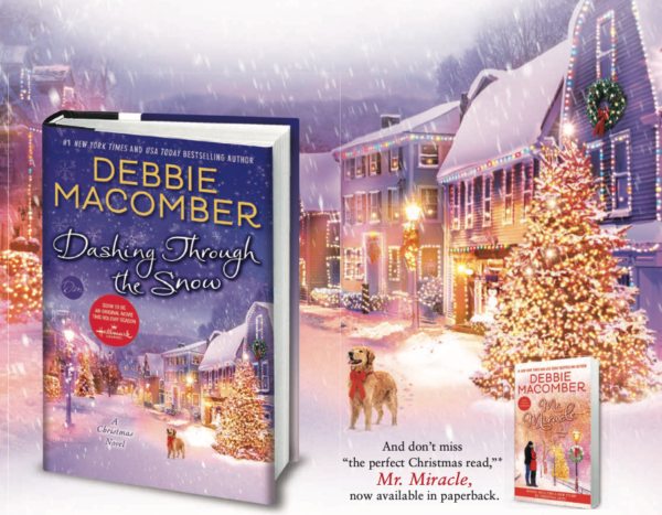 A winter town covered in snow with lit trees, buildings, and a dog with a big bow around his neck, with the book, featuring the same street scene on the cover