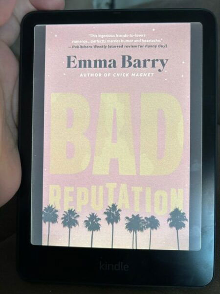 The cover of Bad Reputation by Emma Barry. The font is bright orange which bleeds into the hot pink background.