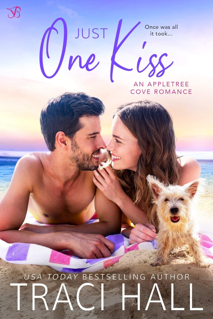 One Kiss by Traci Hall. A brunette man and woman are lying on a striped towel on a beach. Their proportions look off with big heads and tiny shoulders and arms. A scraggly terrier that also looks both too big and too small is looking at us the reader while the two people go in for a kiss.