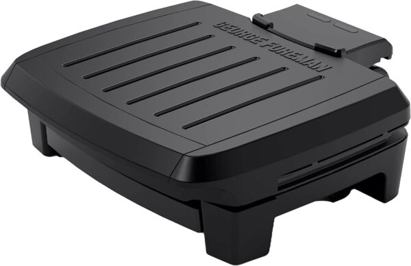 A black nonstick countertop grill with lines on the top. The edge reads GEORGE FOREMAN