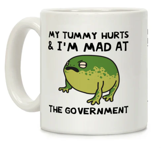 A white mug with an illustration of a round frog with closed eyes and a frown. Above it says My Tummy Hurts and I'm mad at, and below, it says The Government 
