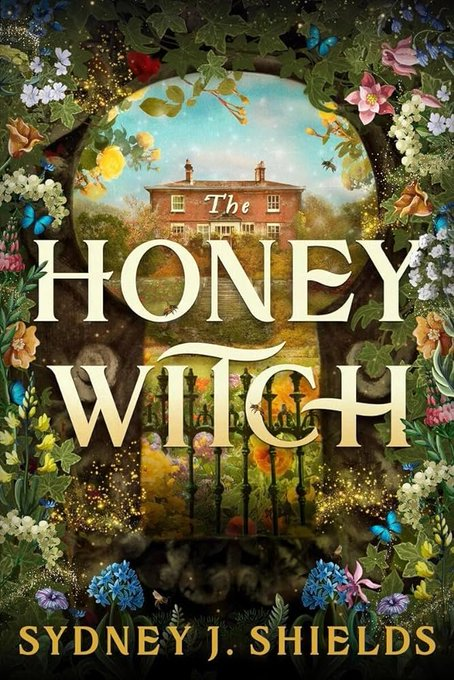The Honey Witch by Sydney J. Shields. A tan colored, two story estate sits on a green hill in the background. We are looking at it through a keyhole shaped window with a wrought iron gate at the bottom and its borders surrounded by delicate pastel flowers.