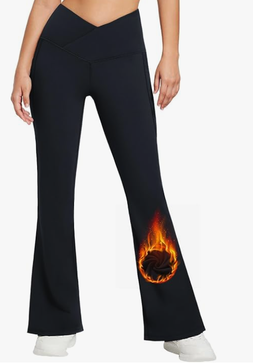 A woman with light skin is wearing a pair of black pants with a high v waist line, and white sneakers. There is a flaming ball of something on the leg, probably to denote that they are warm