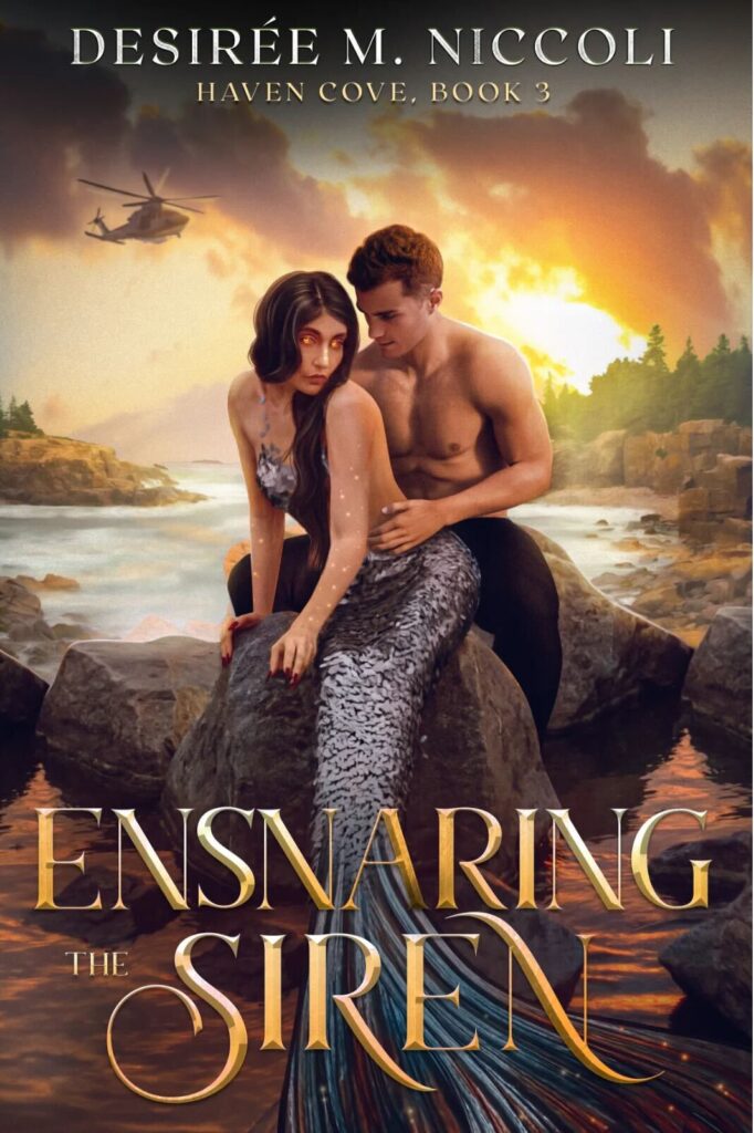 Ensnaring the Siren by Desiree M. Niccoli. A man and woman are sitting on a rock in front of a rocky beach. The man is behind the woman, shirtless and wearing black pants. The woman is a mermaid and she's sitting between the man's legs. Her fish tail is light purple with a matching bra. She has black hair that is positioned over one shoulder and her eyes are glowing red. In the background in the sky is a helicopter.