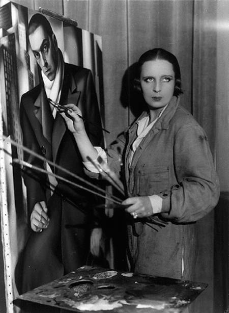 Tamara standing and painting, looking just to the side of the camera