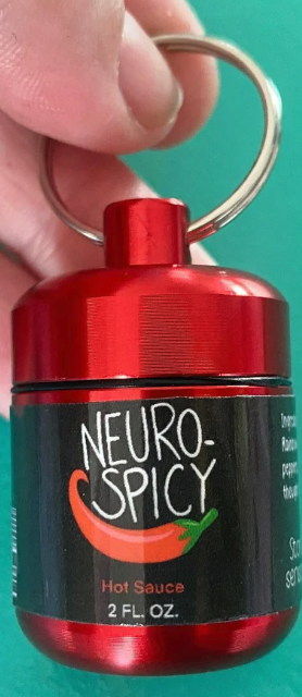A red bottle pill holder with a label that says Neurospicy hot sauce