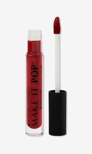 A red lipgloss from Black Girl Sunscreen in French Kiss, a deep red shade. The handle of the applicator is black and the color tube is very deep red