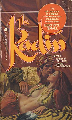 The Kadin - an illustration of a blonde man reaching over a reclining red haired woman. She is wearing a short open bolero top and he appears to be about to pull the fabric away 