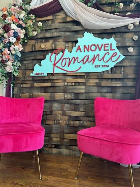 two hot pink chairs with the shop logo behind it
