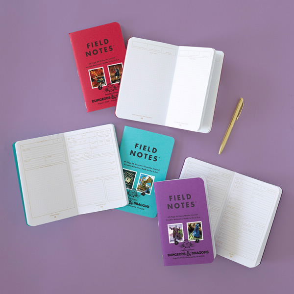 A red, blue, and purple Field notes journal with D&D stamps on the front. The pages are open to show the format of the journals.