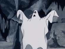 a cartoon sheet ghost waves its arms and hovers in a grey cave