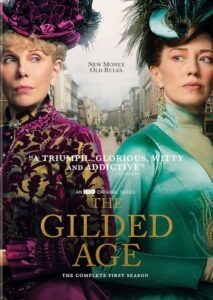 the gilded age season 1 poster with Christine Baranski in deep purple velvet and a BIG HAT standing back to back with a younger woman with brown hair and a teal shiny gown