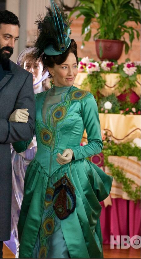 Bertha Russell wears an emerald gown designed with peacock feather motifs